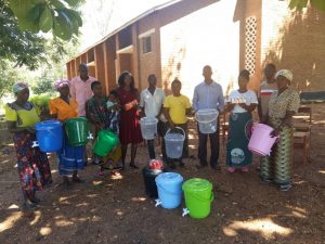 Unsere malawischen Familien halten dankbar die Wassereimer und Seifenstücke in der Hand